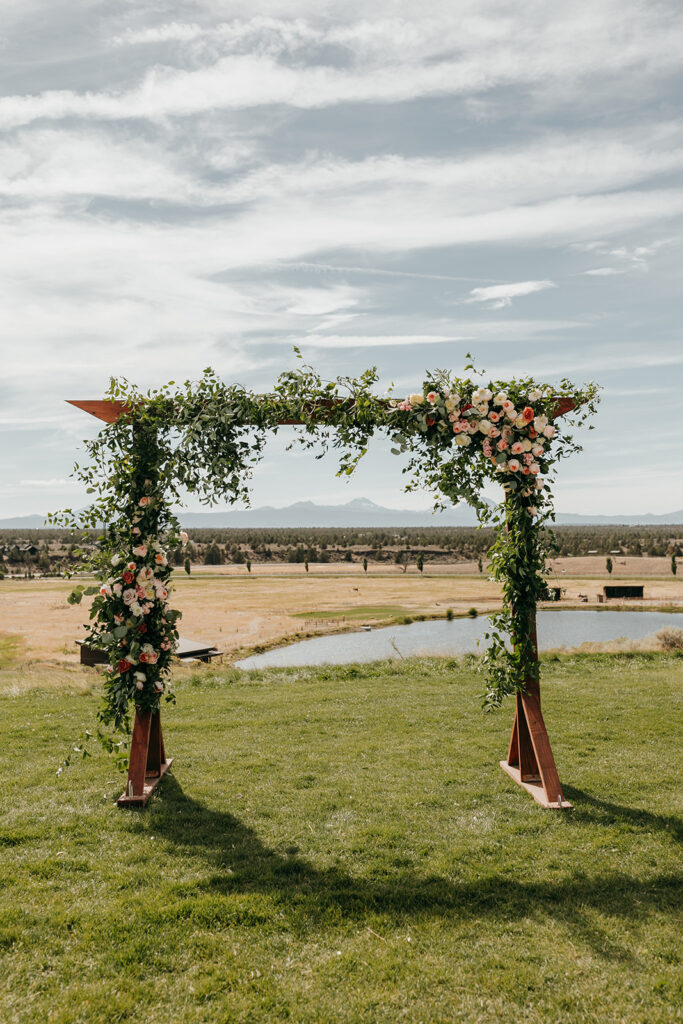 arbor backdrop for wedding featuring sophisticated smilax and florals