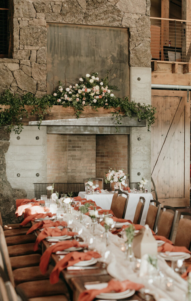 the main room at brasada ranch decorated for the wedding featuring sophisticated florals on the mantel and down the length of the tables